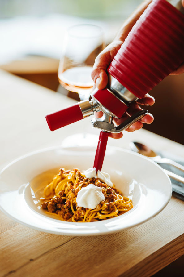 Spaghetti Bolognese, serviert mit frischer Sahne